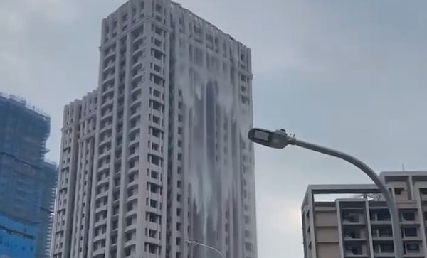 ▲位於淡水區豪宅建案，頂樓露天泳池內的池水因強震搖晃，從高樓向下傾瀉。（圖／網友提供）